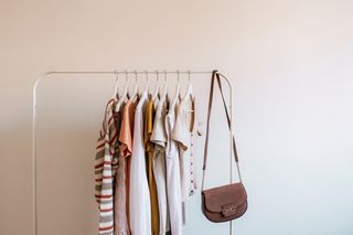 A clothes rail with clothes and bags hanging up